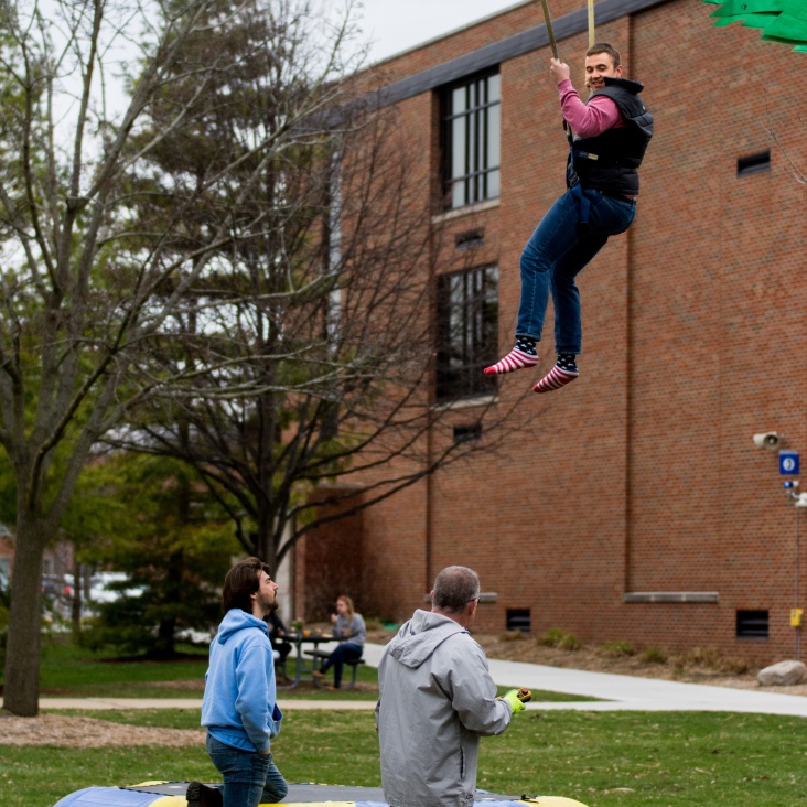 Wixom senior Philip Mitchell bungee jumps during Central Michigan University's annual Maroonzie outside Wariner Hall, Friday, April 27, 2018.